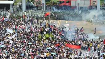 epa03399644 Riot police fire tear gas at protesters outside the city headquarters of Communist Party of China during an anti-Japan protest in Shenzhen in south China's Guangdong province 16 September 2012. Protests across several Chinese cities continued, in the country's ongoing row with Japan over disputed islands in the South China Sea. In the capital, Beijing, several thousand people, mostly young, carried Chinese flags and images of Mao in front of the Japanese embassy. Police were seen in heavy numbers. The demonstrators called on Japan to withdraw from the islands. The dispute between the two countries escalated on Friday when six Chinese ships began patrolling the waters around the islands. EPA/LAN QING CHINA OUT