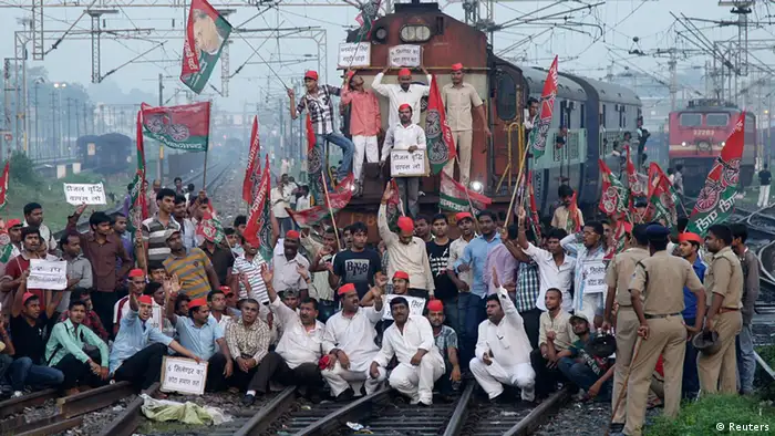 Demonstrators from the Samajwadi Party, a regional political party, shout slogans after they stopped a passenger train during a protest against price hikes in fuel and foreign direct investment (FDI) in retail, near Allahabad railway station September 20, 2012. The signs read, Roll back the price of diesel, End the 6-cylinder cap and Manmohan Singh leave your seat. REUTERS/Jitendra Prakash (INDIA - Tags: POLITICS BUSINESS CIVIL UNREST TRANSPORT TPX IMAGES OF THE DAY)