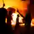 Demonstranten vor brennendem Auto im Hauptquartier der Ansar al-Scharia Miliz (Foto: REUTERS)