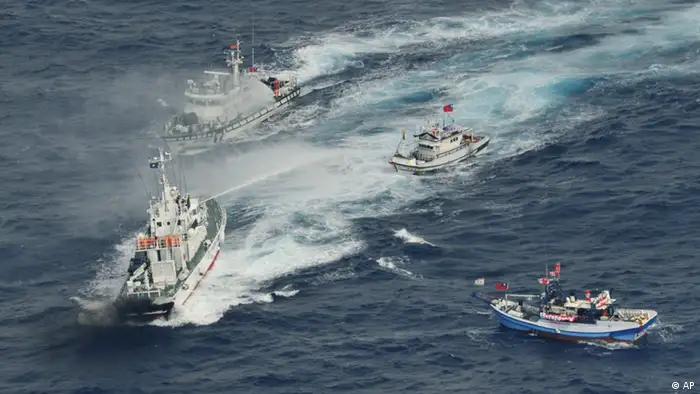 A Japan Coast Guard's patrol boat, left bottom, discharges water against Taiwanese fishing boats near disputed islands called Senkaku in Japan and Diaoyu in China, in the East China Sea, Tuesday, Sept. 25, 2012. On Tuesday morning, about 50 Taiwanese fishing boats accompanied by 10 Taiwanese surveillance ships came within almost 20 kilometers (about 12 miles) of the disputed islands - within what Japan considers to be its territorial waters, said Yasuhiko Oku, an official with the Japanese coast guard. (Foto:Kyodo News/AP/dapd) JAPAN OUT, MANDATORY CREDIT, NO LICENSING IN CHINA, FRANCE, HONG KONG, JAPAN AND SOUTH KOREA