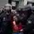 Police carrying a woman at a protest in Madrid