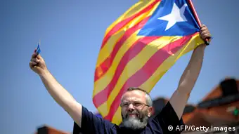 A man holds a catalan independentist flag 'la senyera' during a potest of the No Vull Pagar (I don't want to pay) movement during a demostration in Mollet's toll on July 29, 2012 in Mollet del Valles near Barcelona. Followers of the pressure group No Vull Pagar (I don't want to pay) who refuse to pay highway tolls, demonstrated against the toll company Abertis, owned by La Caixa. AFP PHOTO/JOSEP LAGO (Photo credit should read JOSEP LAGO/AFP/GettyImages)