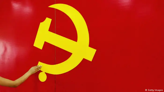 BEIJING - JUNE 15: An outstrected hand touches the Hammer and Sickle logo at an exhibition promoting the Chinese Communist Party on June 15, 2005 in Beijing, China. A senior official of the Communist Party of China (CPC) has urged officials in charge of discipline inspection and supervision to be fully aware of the vital importance of improving the Party's work style and building a clean government. (Photo by Guang Niu/Getty Images)