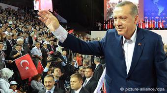 Der türkische Premierminister Erdogan winkt zu einer Masse von Anhängern bei einer Veranstaltung der AKP (Foto: dpa)