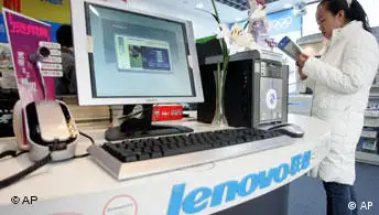 A Chinese woman examines a pamphlet near Lenovo computers on display at a computer shop in Beijing, China, Wednesday, Dec. 8, 2004. China's biggest computer maker, Lenovo Group, said Wednesday it has acquired a majority stake in IBM Corp.'s personal computer business in a deal valued at US$1.75 billion (euro1.32 billion) _ one of the biggest Chinese overseas acquisitions ever. (AP Photo/Ng Han Guan)