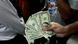 A close-up of a Tehran trader's hand clasping dollar notes Lizenz: DW A close-up of a Tehran trader's hand clasping dollar notes Lizenz: DW