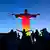 Touristen fotografieren die schwarz-rot-geoldene Christus-Statue in Rio de Janeiro (Foto: REUTERS)