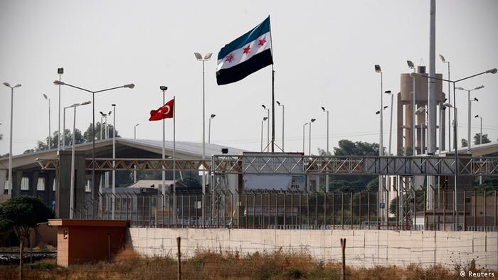 Turkish and Syrian Independence flags are seen between the border gates Akcakale of Turkey and Tel Abyad of Syria, 
Photo: REUTERS/Murad Sezer 