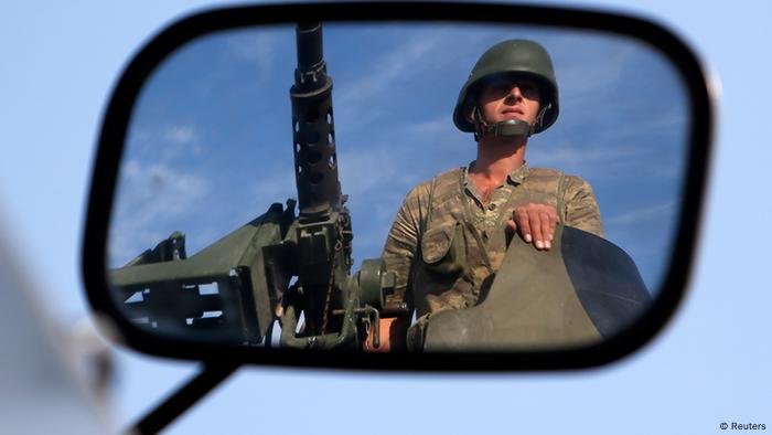 A Turkish soldier is reflected on a mirror as he stands guard on top of an armored personnel carrier on the Turkish-Syrian border near the Akcakale border crossing
Photo: REUTERS/Murad Sezer 