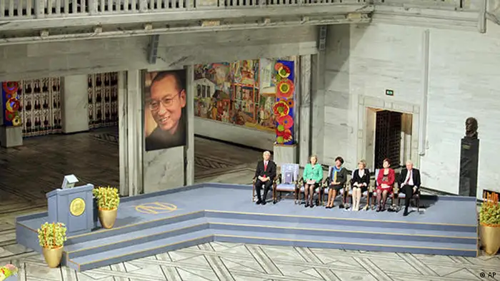 An empty lecturn for Nobel Peace Prize laureate Liu Xiaobo is seen during a ceremony honoring Liu at city hall in Oslo, Norway Friday Dec. 10, 2010. Liu, a democracy activist, is serving an 11-year prison sentence in China on subversion charges brought after he co-authored a bold call for sweeping changes to Beijing's one-party communist political system. The chair second from left hold Liu's Nobel diploma and medal (AP Photo/John McConnico)