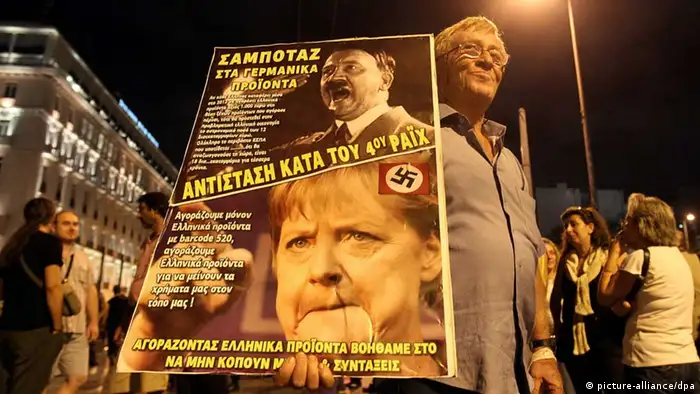 epa03425966 A demonstrator holds a poster depicting Adolf Hitler and German Chancellor Angela Merkel during a protest in front of the Parliament building against new austerity measures in Athens, Greece, 08 October 2012. The protest, called by trade unions, took place one day ahead the visit of German Chancellor Angela Merkel in Athens. The banner reads 'Dont buy German products, Resistance against fourth Reich'. EPA/ORESTIS PANAGIOTOU +++(c) dpa - Bildfunk+++