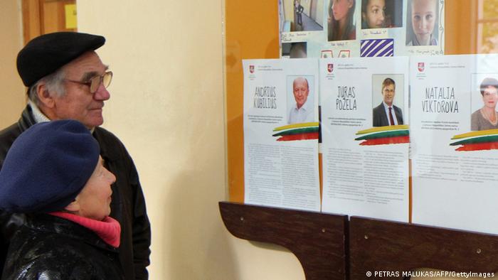 Voters read about the candidates for the parliamentary elections at a polling station in Vilnius, AFP PHOTO / PETRAS MALUKAS (Photo credit should read PETRAS MALUKAS/AFP/GettyImages)