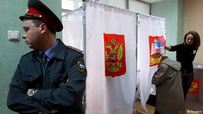 A police offer stands next to voting booths in Russia during local elections in 2012 (Photo: Sergei Karpukhin)