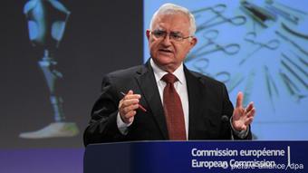  John Dalli stands at a European Commission lectern in 2012, a pen in his right hand