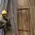 Ein Wanderarbeiter ruht sich auf Stahlstreben auf einer Baustelle in Jinan aus (Foto: picture-alliance/dpa)