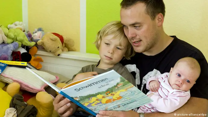 Vater liest Kinder aus einem Buch vor
