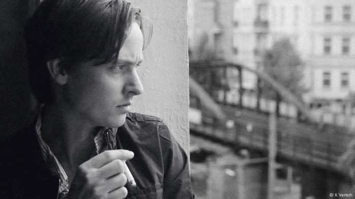 Tom Schilling in Oh Boy mit Zigarette aus Fenster blickend