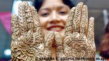 Dhaka, BANGLADESH: A Bangladeshi woman shows her hands, decorated with henna, during a Mehendi Festival (Henna Festival) in Dhaka, 20 October 2006. Henna, which is believed to have been used as a cosmetic for over 5000 years in Egypt and Middle Eastern countries, is a popular form of fashion among women, especially during the Eid Festival. AFP PHOTO/Farjana K. GODHULY (Photo credit should read FARJANA K. GODHULY/AFP/Getty Images)