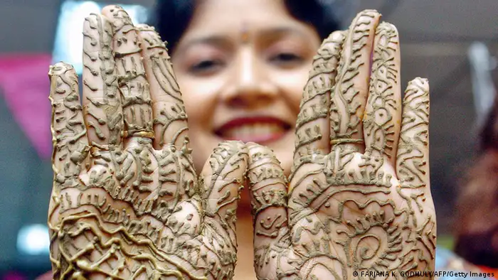 Dhaka, BANGLADESH: A Bangladeshi woman shows her hands, decorated with henna, during a Mehendi Festival (Henna Festival) in Dhaka, 20 October 2006. Henna, which is believed to have been used as a cosmetic for over 5000 years in Egypt and Middle Eastern countries, is a popular form of fashion among women, especially during the Eid Festival. AFP PHOTO/Farjana K. GODHULY (Photo credit should read FARJANA K. GODHULY/AFP/Getty Images)