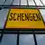A black, iron gate has a yellow sign in the center that reads, "Schengen." (Photo: no info)