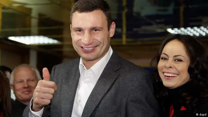 Chairman of the Ukrainian democratic opposition Ukrainian Democratic Alliance for Reform Party and former boxing champion, Vitali Klitschko gestures to photographers, after voting, at a polling station during parliamentary elections in Kiev, Ukraine, Sunday, Oct. 28, 2012. Ukrainians are electing a parliament on Sunday in a crucial vote tainted by the jailing of top opposition leader Yulia Tymoshenko and fears of election fraud. His wife Natalia is seen right. (Foto:Efrem Lukatsky/AP/dapd)