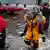 A rescue worker carries a boy on his back as emergency personnel rescue residents from flood waters brought on by Hurricane Sandy