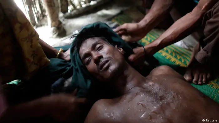 Mohammad Nur, 28, faints while hiding with his wife Samuda Khatun and son Shahid Noor in a house in Teknaf October 30, 2012. Nur, who belongs to a group of Rohingya Muslims currently hiding with local villagers to avoid being arrested by border guards of Bangladesh, walked a whole day and night with his wife and son to neighbouring Bangladesh after fleeing the mass burning of houses and violence in Myanmar. REUTERS/Andrew Biraj (BANGLADESH - Tags: SOCIETY CIVIL UNREST)