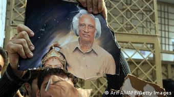 Pakistani demonstrators tear the photo of the school owner during a protest (Photo: Arif Ali/AFP/Getty Images)