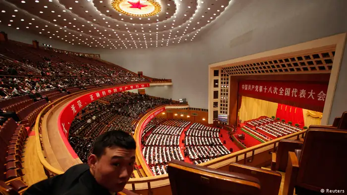 A security officer looks back as China's President Hu Jintao delivering a speech during the opening ceremony of 18th National Congress of the Communist Party of China at the Great Hall of the People in Beijing, November 8, 2012. REUTERS/Carlos Barria (CHINA - Tags: POLITICS)