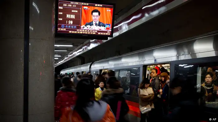Commuters walk past a TV showing a live broadcasting of Chinese President Hu Jintao's remarks during the opening session of the 18th Communist Party Congress, at a subway station in Beijing, China, Thursday, Nov. 8, 2012. Preparing to hand over power after a decade in office, China's President Hu Jintao called Thursday for sterner measures to combat official corruption that has stoked public anger while urging the Communist Party to maintain firm political control. (Foto:Andy Wong/AP/dapd).