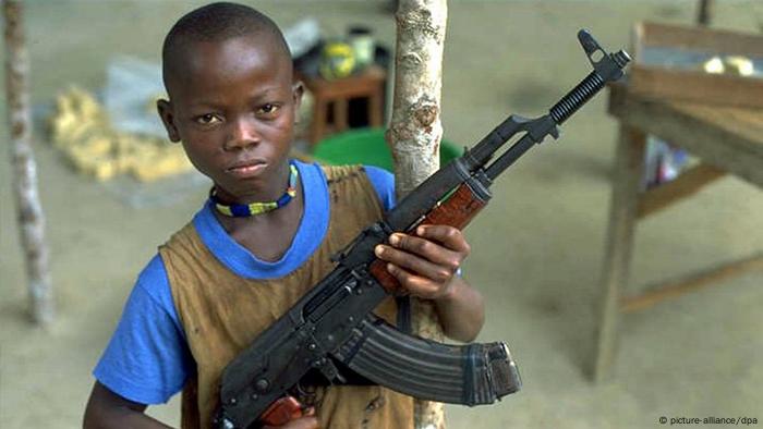 Ein zwöfjähriger Kindersoldat in der Stadt Bo in Sierra Leone präsentiert seine Kalaschnikow.