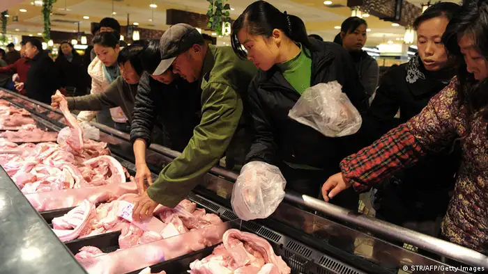In this photograph taken on March 8, 2012, a Chinese worker arranges food at a supermarket before opening in Beijing. China's inflation rate slowed sharply in February from the previous month, official data showed, giving Beijing more room to loosen credit restrictions to boost flagging economic growth. CHINA OUT AFP PHOTO (Photo credit should read STR/AFP/Getty Images)