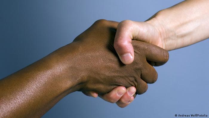 Zwei Hände, schwarz und weiß, halten einander fest (Copyright:Andreas Wolf) Symbolbild Entwicklungshelfer, Entwicklungshilfe,