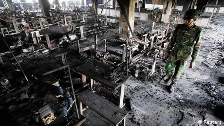 A soldier inspects the damage after a garment factory fire