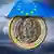A Spanish euro coin under an umbrella symbolizing the eurozone's ESM rescue fund