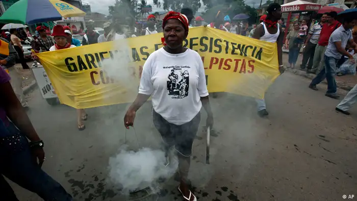 A member of the Garifuna ethnic group carries burning herbs during a traditional protection ritual at a rally in support of Honduras' ousted President Manuel Zelaya in Tegucigalpa, Tuesday, Sept. 8, 2009. (ddp images/AP Photo/Esteban Felix)