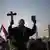 Egyptian man holding a Koran and a cross