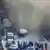 Polizeifahrzeuge vor dem Tunnel, aus dem Rauch drängt (Foto: AP)