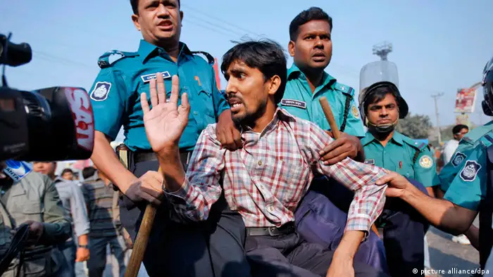epa03495676 An activist of the Jamaat-e-Islami is being carried to a police van after an arrest during the country wide dawn-to-dusk strike at Malibagh in Dhaka, Bangladesh 04 December 2012. The Jamaat activists staged several processions in the city, smashed vehicles and set two buses on fire as the organization enforced the strike demanding the release of their top leaders detained and under trials of war crimes in the war in 1971. EPA/ABIR ABDULLAH