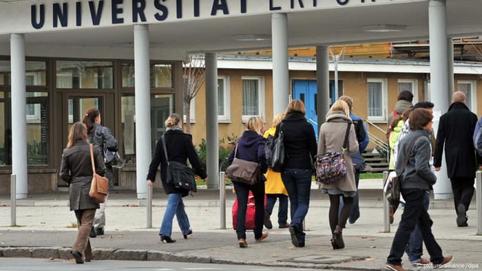 Studierende betreten das Universitätsgelände.