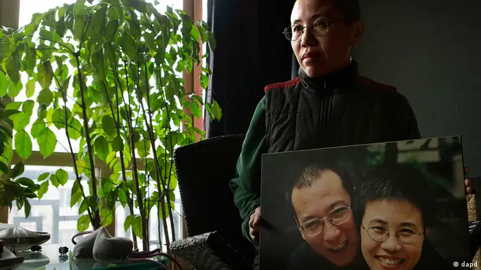 Liu Xia, wife of 2010 Nobel Peace Prize winner Liu Xiaobo, poses with a photo of her and her husband during her first interview in more than two years at her home in Beijing, China, on Thursday, Dec. 6, 2012. Liu trembled uncontrollably and cried Thursday as she described how her confinement under house arrest has been absurd and emotionally draining in the two years since her jailed activist husband was named a Nobel Peace laureate. (Foto:Ng Han Guan/AP/dapd)