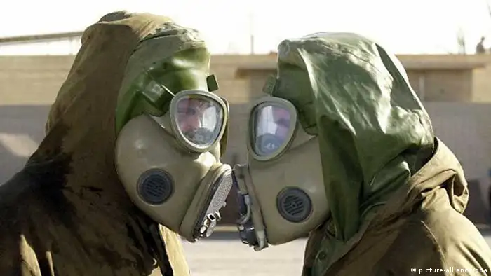 Zwei tschechische Soldaten einer Einheit, die auf den Schutz vor Chemie-Waffen spezialisiert ist, unterhalten sich am 25.6.2002 bei einem Manöver auf der amerikanischen Militärbasis in Doha (Kuwait) durch ihre Gasmasken hindurch.