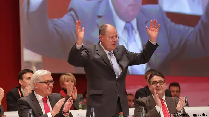 SPD-Kanzlerkandidat Peer Steinbrück steht mit erhobenen Händen am 09.12.2012 beim außerordentlichen Bundesparteitag der SPD in Hannover neben Frank-Walter Steinmeier (l), Fraktionsvorsitzender der SPD-Bundestagsfraktion, und Sigmar Gabriel (r), SPD-Vorsitzender, die ihm beide applaudieren, Foto: Michael Kappeler/ dpa