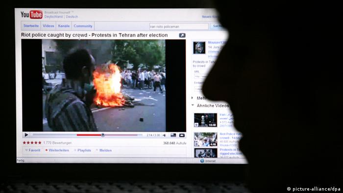 Mann betrachtet Video von den Unruhen in Teheran 2009 (Foto: dpa)