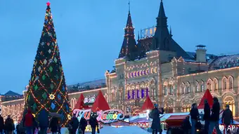 In this Dec. 4, 2012 file photo, people walk past a Christmas tree in Red Square, with the GUM State Department Store at right, in Moscow. (Foto:Alexander Zemlianichenko, File/AP/dapd)