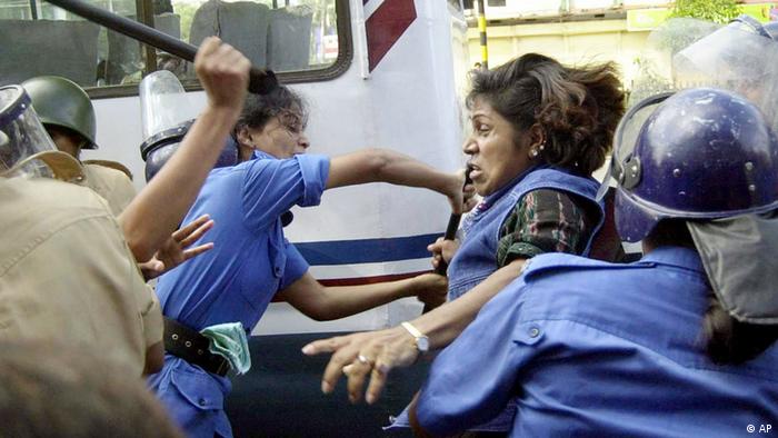 Bangladeshi policewomen use baton and try to arrest an acitivst, center right, of main opposition Awami League during a nationwide strike in Dhaka, Bangladesh, Saturday, Sept. 27, 2003. The strike was called against Prime Minister Khaleda Zia's government inability to curb murders and extortions. (AP Photo/Pavel Rahman)