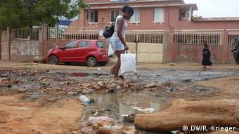 No bairro do Cazenga, ruas esburacadas, lixo e poças d'água: governo prometeu melhorar acesso à água potável e à energia