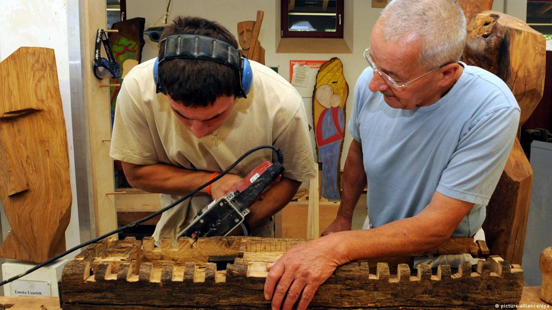 Genç bir hükümlüye ahşap çalışmasını öğreten heykeltıraş