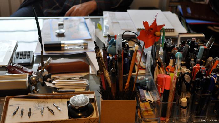 Rozental's desk covered with stacks of paper and cups holding pens and pencils