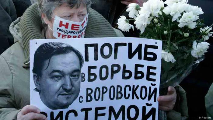 Woman with a poster with a portrait of Sergei Magnitsky